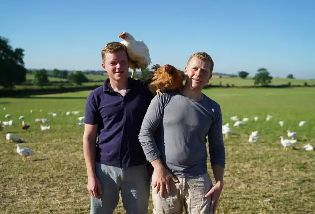 Jacob and Nick with chickens on the farm