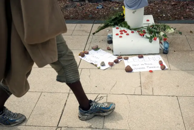 People pay their respects to Winnie Madikizela-Mandela with messages of condolence and flowers in Durban