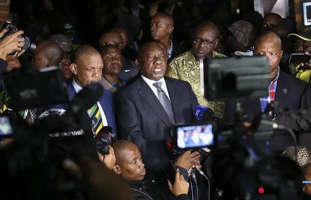 South African president Cyril Ramaphosa (C) speaks outside Winnie Madikizela-Mandela"s home in Soweto, Johannesburg