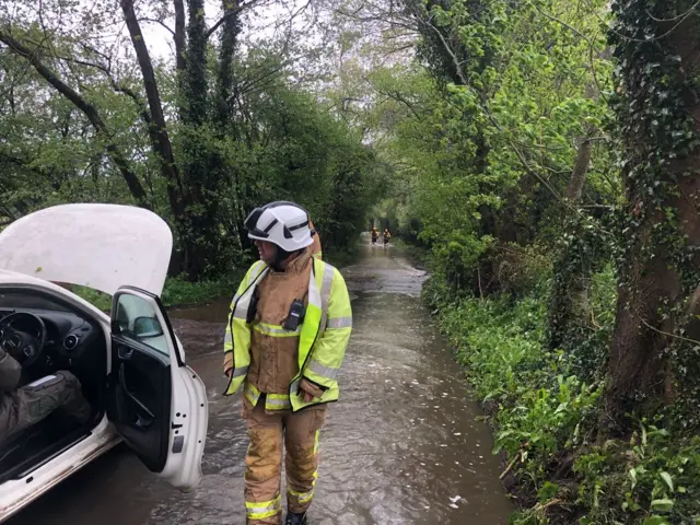 Firefighters rescuing people from a car