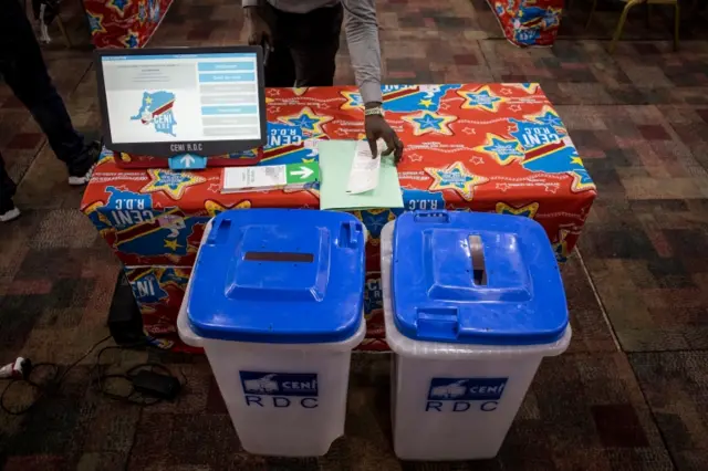 A new voting machine to be used during the Democratic Republic of the Congo"s (DRC) elections sits on a table beside two ballot boxes on February 21, 2018 in Kinshasa.