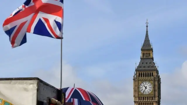 A Union flag and a sign reading "Sale on" are pictured near the Elizabeth Tower, better known as "Big Ben", and the Houses of Parliament in central London on March 6, 2017