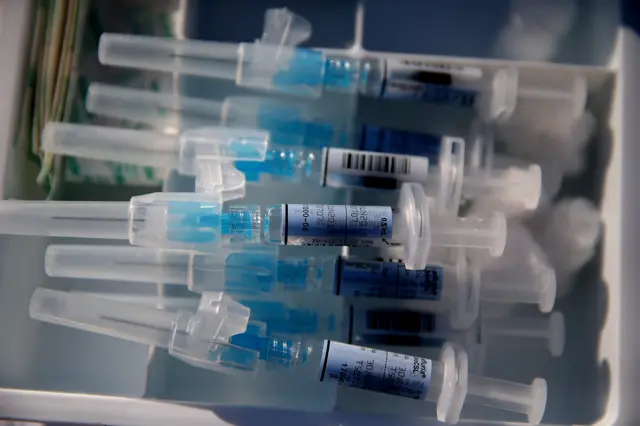 Syringes filled with flu vaccine sit on a table during a drive-thru flu shot clinic at Doctors Medical Center on November 6, 2014 in San Pablo, California.