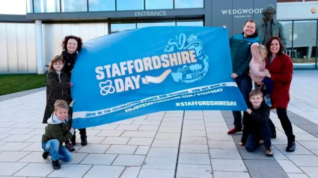 People with a Staffordshire Day poster at the Wedgwood Institute