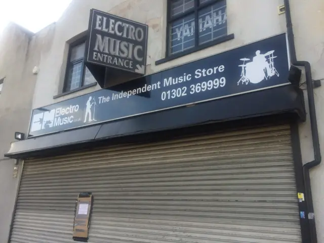 Shutters and sign outside Electro Music