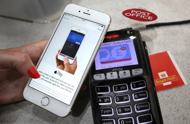 In this photo illustration, an iPhone is used to make an Apple Pay purchase at The Post Office on July 14, 2015 in London, England.