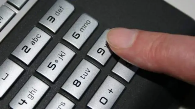 Hand on a telephone keypad