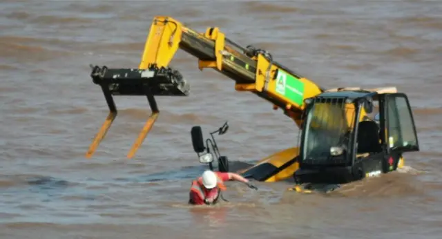 Th JCB and a worker in the water.