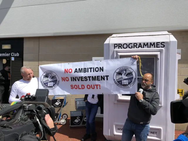 Two fans with a banner before kick off at the Liberty Stadium