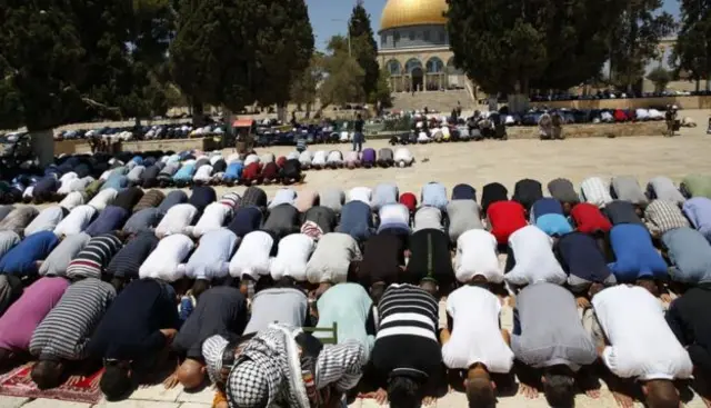 Muslim worshippers attend Friday noon prayers near the Dome of the Rock mosque in Jerusalem