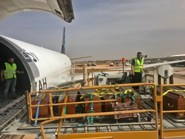 Coffins containing the remains of 20 Egyptian Coptic Christians beheaded by jihadists on the beach in Sirte in 2015 are loaded onto a plane in Misrata prior to being expatriated to Cairo on May 14, 2018