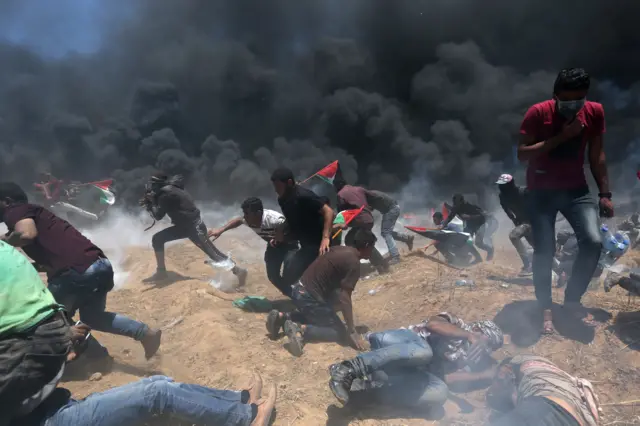 Protester scramble for cover near the Gaza border