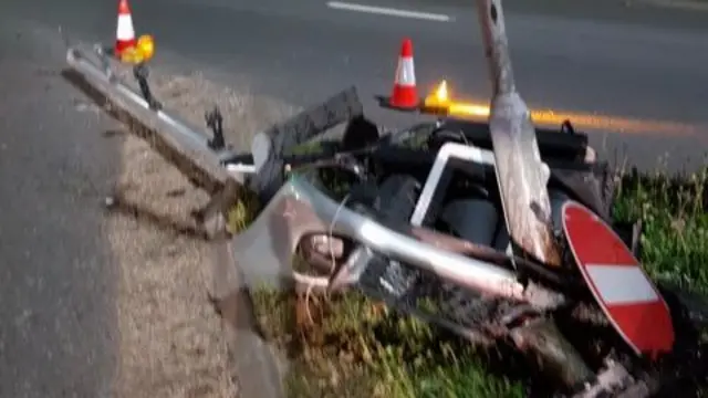 Bits of a car near a road sign