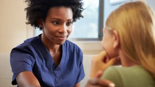 Child being comforted by healthcare professional