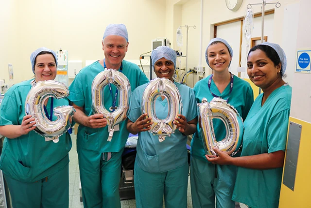 surgical staff holding balloons reading 'good'