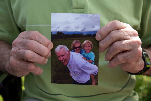 elderly person holding a photo of a family