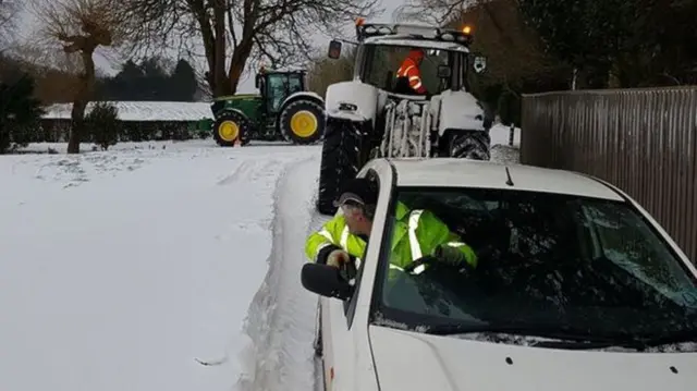 Farmers help cars out of the snow