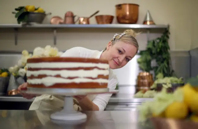 Claire Ptak, owner of Violet Bakery in Hackney, east London, puts finishing touches to the cake