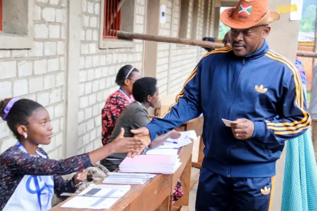 Burundi President Pierre Nkurunziza is registered by an electoral official before casting his ballot at a polling centre