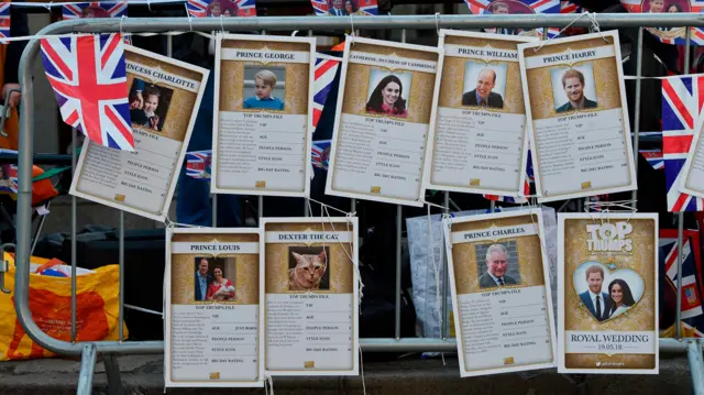 Giant 'top trump' cards for each member of the royal family, tied to a railing