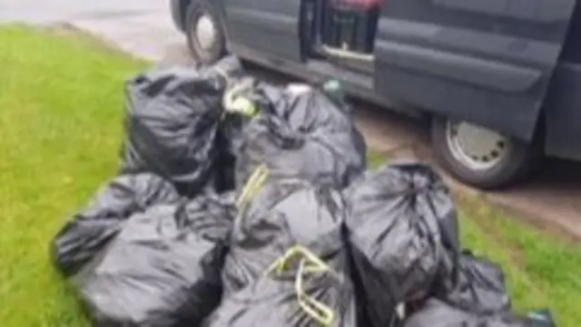 Bags of rubbish next to camper van