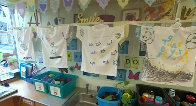 T-shirts painted blue and yellow hanging on a line to dry.