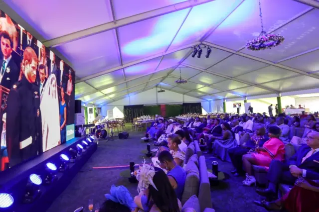 Kenyan royal enthusiasts watch the live broadcast of the UK's royal wedding ceremony on a giant screen at the Windsor Golf Hotel and Country Club in Nairobi on 19 May 2018