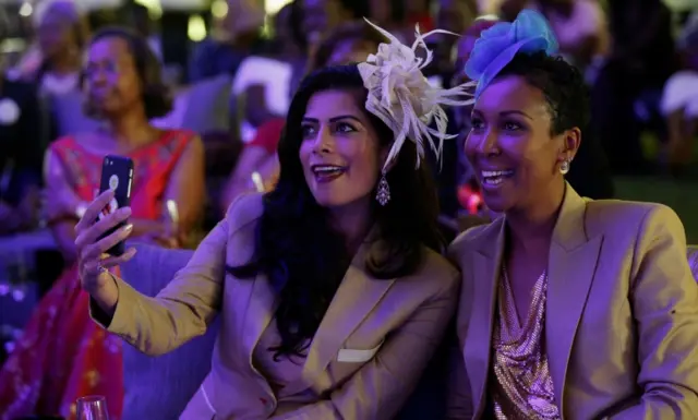 Pinky Ghelani and Suzzy Wokabi sing as they watch a TV broadcast of the UK's royal wedding at the Windsor Golf Hotel and Country Club in Nairobi, Kenya, on 19 May 2018