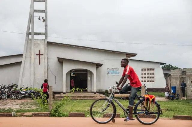 A man drives his bike taxi past the Church of Christ during Pentecost celebrations on 20 May 2018 in Mbandaka, north-west of DR Congo