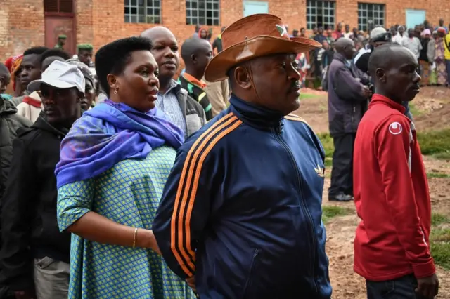 Burundis President Pierre Nkurunziza (2R) waits with his wife Denise (3R) as they queue to cast their votes for the referendum on a controversial constitutional reform in Buye, northern Burundi, on 17 May 2018