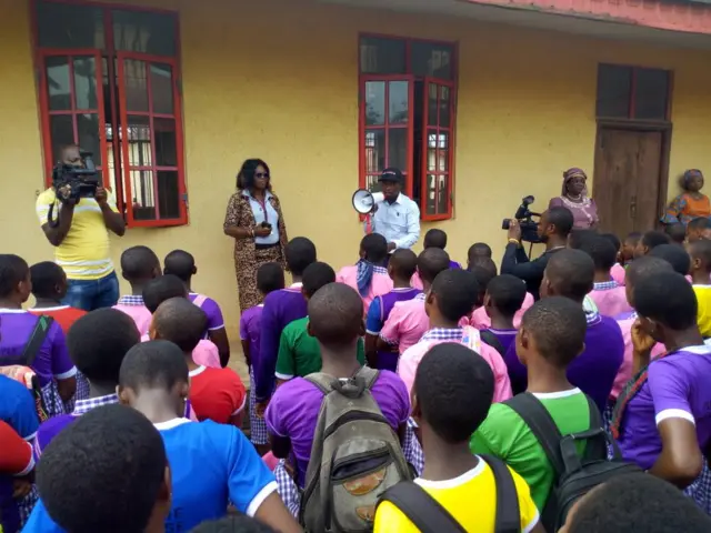 Pupils look on as a man speaks to them about the dangers of human trafficking