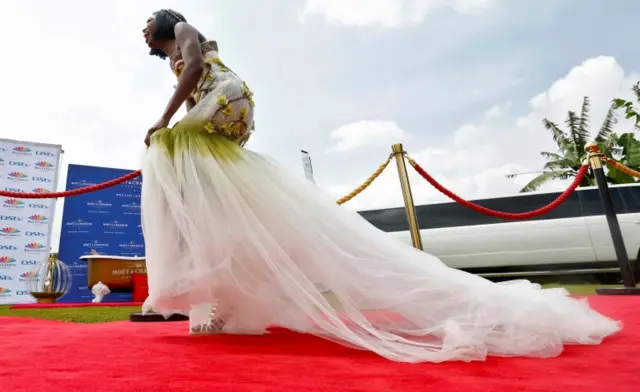 A guest dressed in a wedding gown dances as she arrives to watch the TV broadcast of the royal wedding at the Windsor Golf hotel and country club in Nairobi, Kenya on 19 May 2018