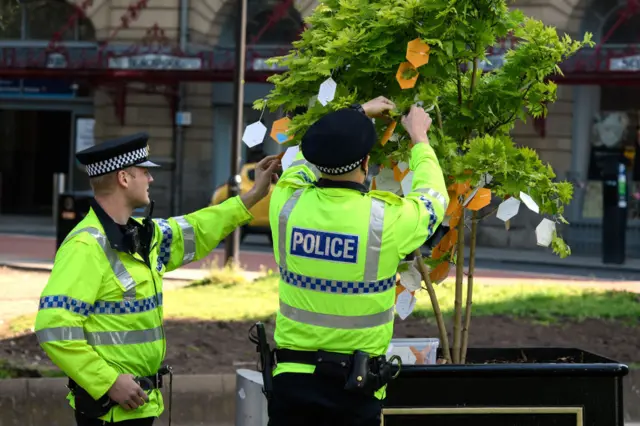 Police hang memorial cards on tree