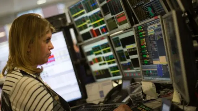 Woman tWhat's driving the FTSE 100 rader in front of screen