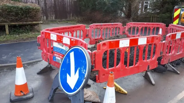 Cordoned off road after burst pipe