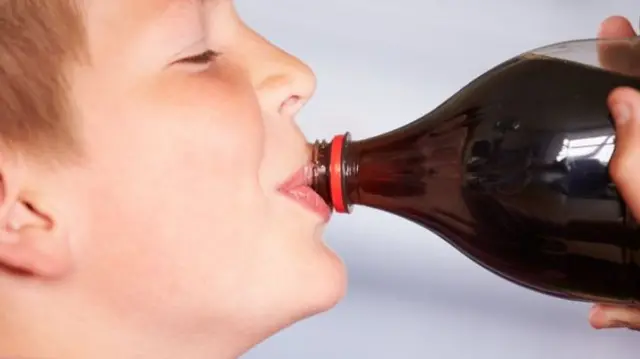 Boy drinking soft drink from bottle