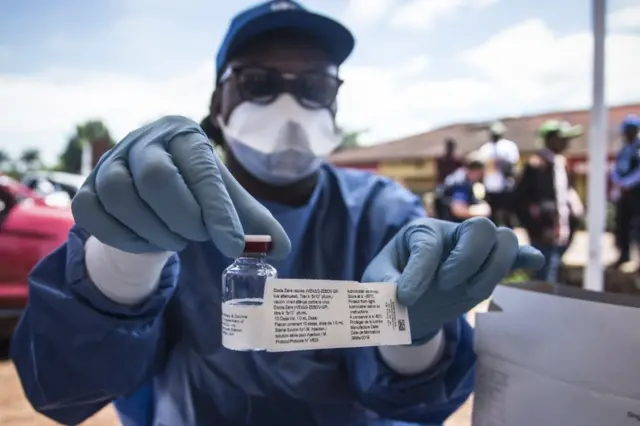 A worker from the World Health Organization (WHO) holds up a vaccination as he prepares to administer it during the launch of an experimental Ebola vaccine in Mbandaka, north-western Democratic Republic of the Congo