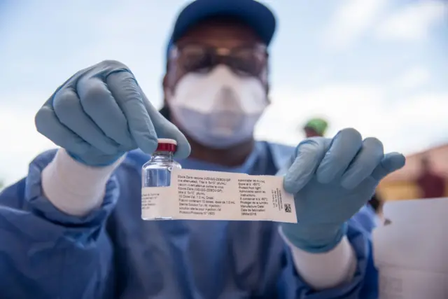 A nurse working with the World Health Organization (WHO) shows a bottle containing Ebola vaccine at the town all of Mbandaka on May 21, 2018 during the launch of the Ebola vaccination campaign. - The death toll in an outbreak of Ebola in the Democratic Republic of Congo (DRC) rose to 26 on May 21, 2018.