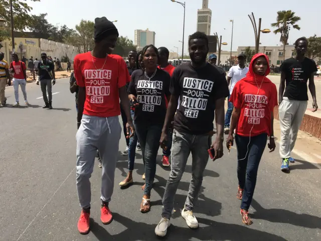 Students walk in the streets wearing Justice for Fallou Sene shirts