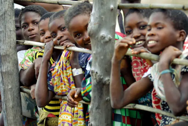 Congolese teen-agers look for friends and relatives as a bus of new arrivels unloads March 25, 2003 in the Kala refugee camp near Kawamba, Zambia.