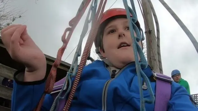 close up of boy in climbing harness