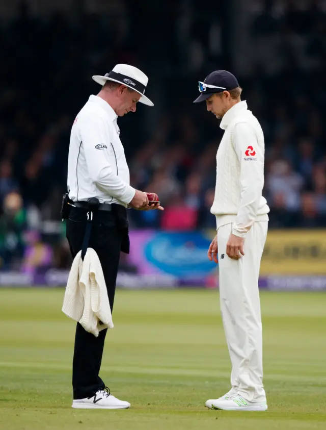 Joe Root and the umpire inspect the condition of the ball