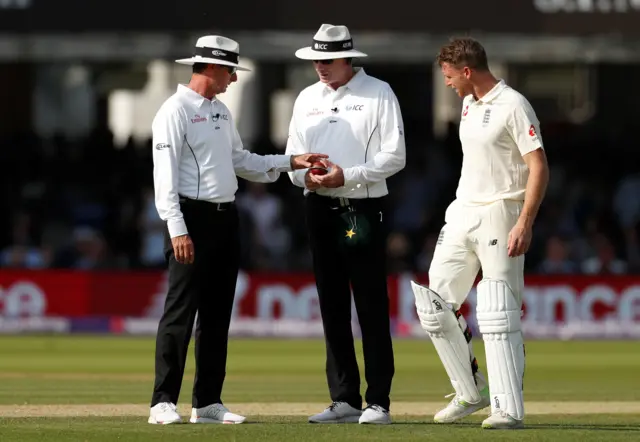 England's Jos Buttler looks on as the umpires check the ball