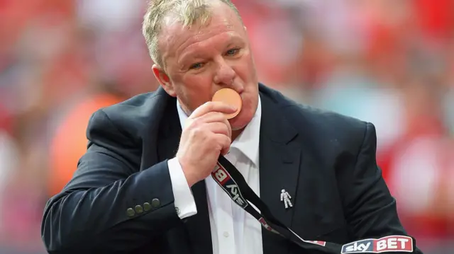 Steve Evans kisses his medal at the League One play-off final in 2014