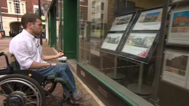 Man in wheelhouse looking in estate agent window