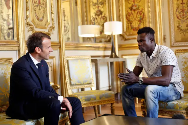 French President Emmanuel Macron (L) speaks with Mamoudou Gassama, 22, from Mali, at the presidential Elysee Palace in Paris, on May, 28, 2018.