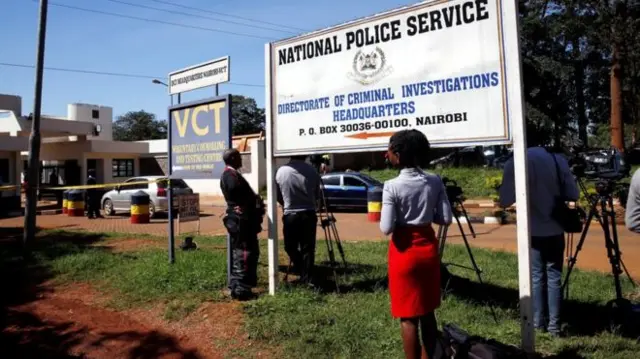 Journalists outside police building