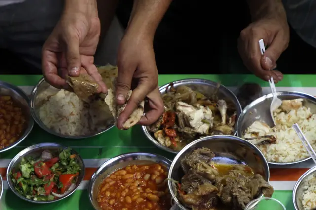 Egyptian Muslims break their day-long Ramadan fast during a group 'Iftar' meal for the residents of a neighbourhood in downtown Cairo on August 18, 2010.