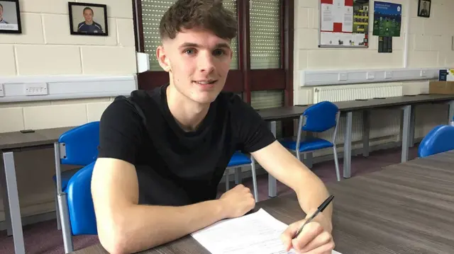 Callum Ainley signing paper