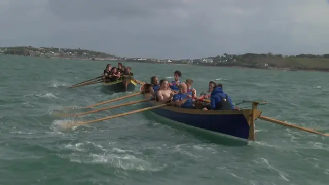 two pilot gigs at sea with island in background